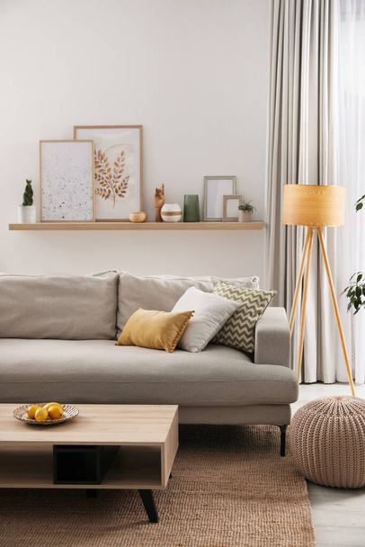 Stylish living room interior with comfortable grey sofa and coffee table - Foto, Bild