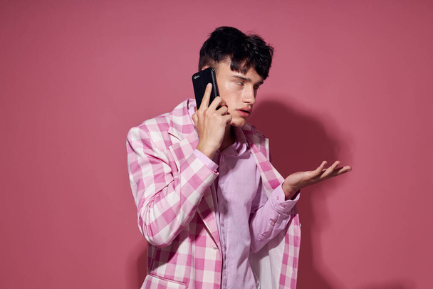 pretty man with a phone in hand pink blazer fashion elegant style isolated background unaltered - Фото, зображення