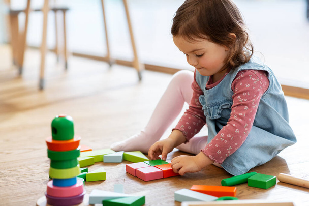 happy baby girl playing with toy blocks at home - Foto, imagen