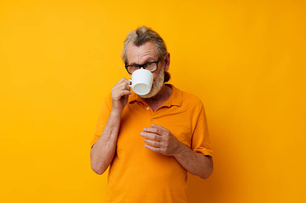 Portrait of happy senior man with a white mug of drink cropped view - Zdjęcie, obraz