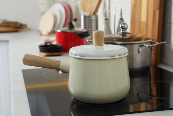 Saucepan on electric stove in kitchen. Cooking utensil - Фото, зображення