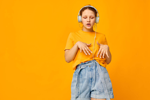 funny girl yellow t-shirt headphones entertainment music fun isolated backgrounds unaltered - Valokuva, kuva