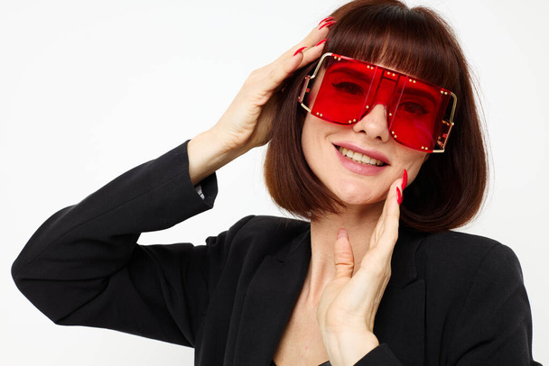 portrait of a woman in red with stylish glasses a leather suit black jacket isolated background - 写真・画像