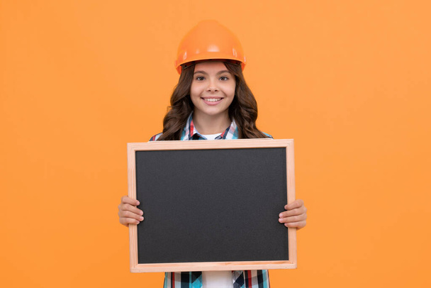 счастливый ребенок в шлеме, представляющий школьную доску с рекламой, копировальным пространством, школьной информацией - Фото, изображение