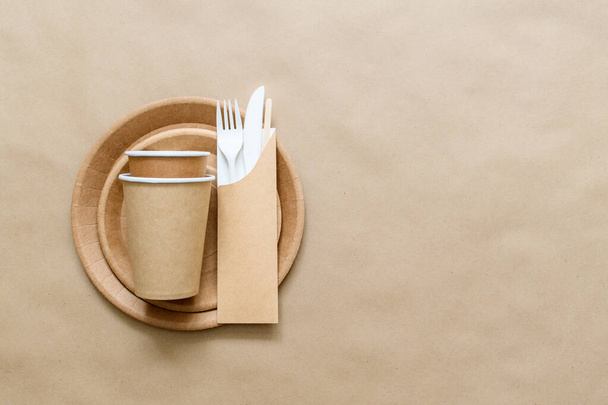 Paper glasses on craf paper plates. Ecological picnic utensils. Flat lay, copy space. - Foto, immagini