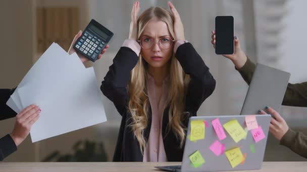 Грустная переутомленная деловая девушка с женщиной-менеджером в очках, держащей голову многозадачными стрессовыми проблемами с работой сидя за столом с ноутбуком вокруг блокнота калькулятора бумаги телефона - Кадры, видео