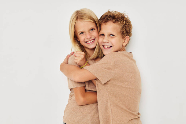 Little boy and girl gesticulate with their hands together light background - Foto, Imagem