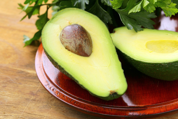 verse organische rijpe avocado op een houten tafel - Foto, afbeelding