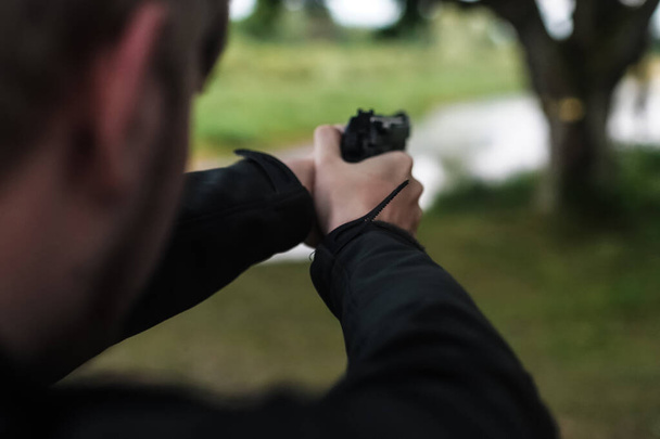 een man met een pistool richt zich op iemand - Foto, afbeelding