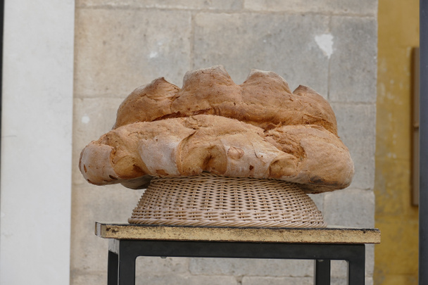 Matera typical bread resting on a stool outside a bakery - Photo, image