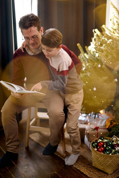 New year, small boy and man reading fairytale. Christmas happy child and father read book. - Φωτογραφία, εικόνα