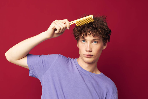 guy with red curly hair comb hair care posing isolated background - Foto, afbeelding
