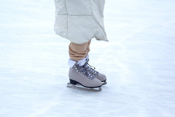 Ice skating on an ice rink. legs with skates. Winter active sport and leisure hobby. - Foto, imagen