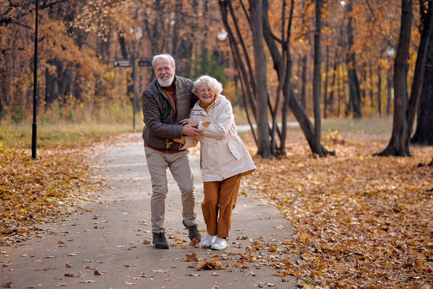 Nature season and fall holiday. Cheerful senior couple of woman and man outdoor - Foto, Imagem