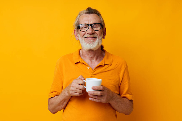 Portrait of happy senior man with a white mug of drink cropped view - Foto, Imagem