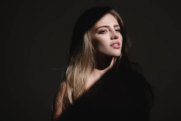 Portrait of beautiful woman model looking seductive and sensual. Beauty face with dramatic studio light isolated on black. Sensual girl. - Фото, изображение