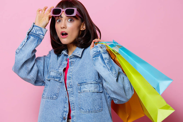 junge Frau in Jeansjacken mit bunten Einkaufstaschen Lifestyle-Mode - Foto, Bild