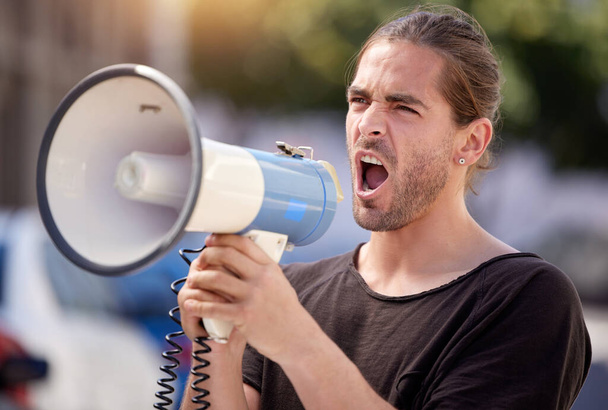 Travailler vers mon but. Plan d'un jeune homme utilisant un mégaphone lors d'un rassemblement de protestation. - Photo, image