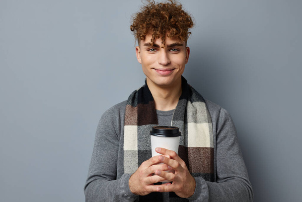 handsome young man checkered scarf posing drink mug light background - Fotoğraf, Görsel