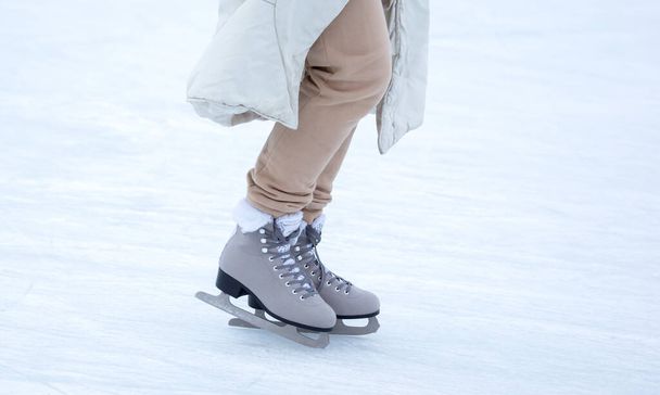 Patinaje sobre hielo en una pista de hielo. piernas con patines. Invierno activo deporte y ocio hobby. - Foto, imagen