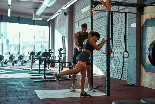 Trainer teaching girl warming up in sport club - Photo, Image