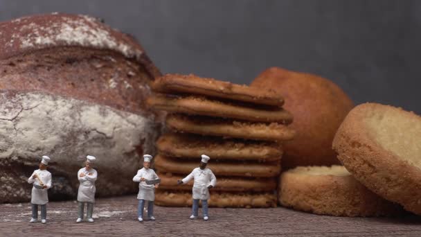 Pieczony chleb i pięciu miniaturowych kucharzy. Miniaturowi ludzie i koncepcja biznesu. - Materiał filmowy, wideo