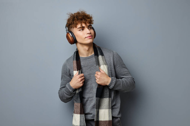 handsome young man elegant style checkered scarf headphones isolated background - Foto, Bild