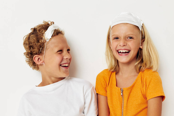two joyful children fun medical mask stand side by side close-up light background - Φωτογραφία, εικόνα