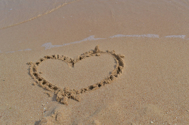 Τραβηγμένη καρδιά στην άμμο κατά τη διάρκεια των καλοκαιρινών διακοπών - Φωτογραφία, εικόνα