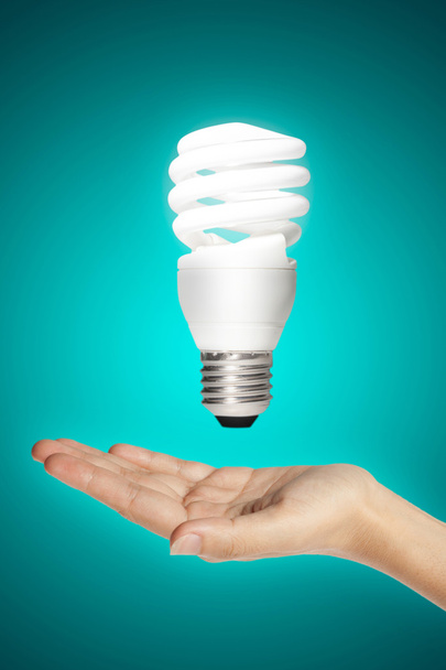 hand body part with energy saving lamp - Foto, Bild