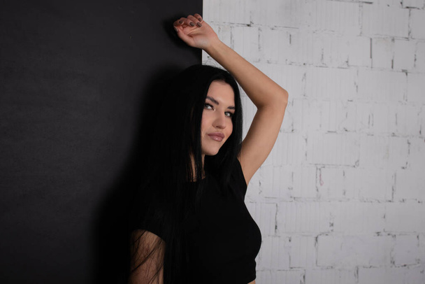 sexy donna bruna in nero contro sfondo muro di mattoni bianchi. ritratto di moda femminile - Foto, immagini