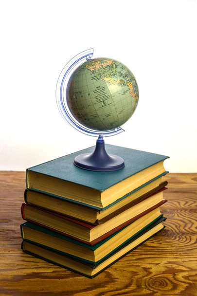 глобус земного шара на стопке книг. Высокое качество фото - Фото, изображение