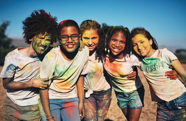Vrienden vullen je leven met kleur. Opname van een groep tieners die plezier hebben met kleurrijk poeder op zomerkamp. - Foto, afbeelding