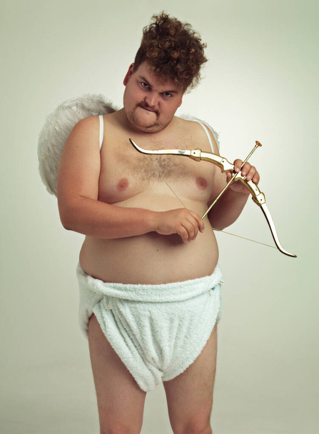 Get ready to fall in love. An obese man dressed as a cherub with a bow and arrow. - Foto, immagini