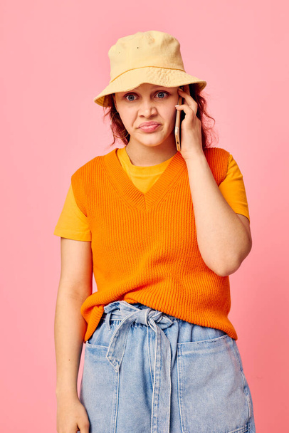 portrait of a young woman communicates on the phone in yellow hat fashion cropped view unaltered - Fotografie, Obrázek