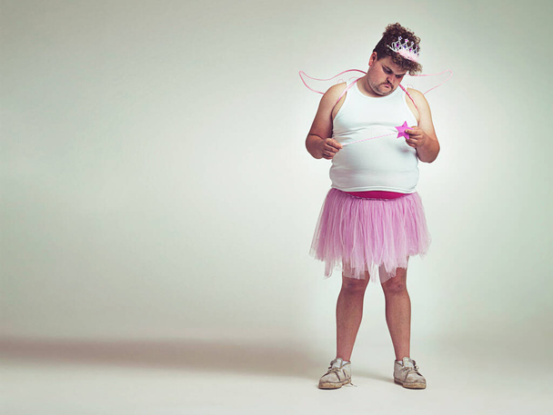 Showing his "lighter" side. An overweight man comically dressed-up in a pink fairy costume looking sad. - Φωτογραφία, εικόνα