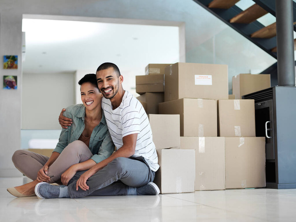Our own home sweet home. Portrait of a happy young couple sitting on their living room floor on moving day. - Foto, imagen