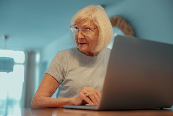 Mujer mayor descansando con el ordenador portátil en casa - Foto, Imagen