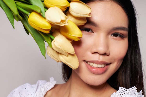 Portrait Asian beautiful young woman romance bouquet of flowers near the face studio model unaltered - Fotoğraf, Görsel