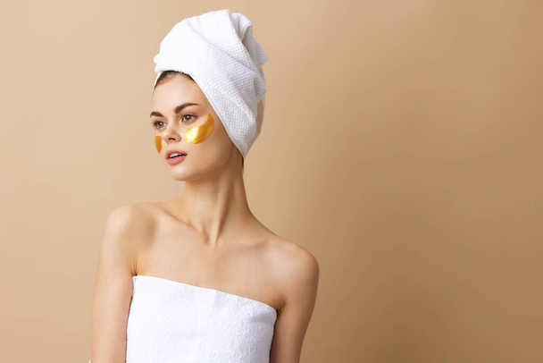 young woman patches rejuvenation skin care fun after shower beige background - Foto, Imagem