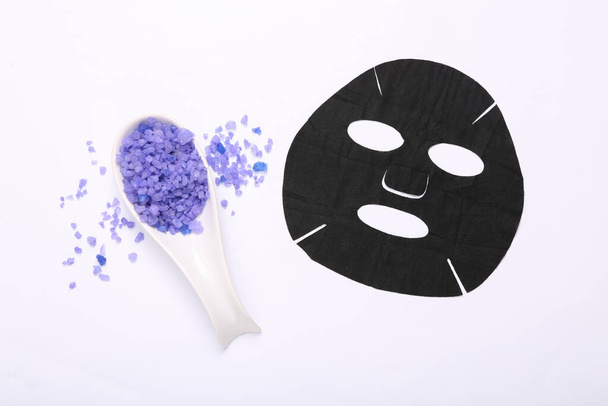 Self-care set. Black cleansing facial mask and bath salt on white background. Natural cosmetics, beauty flat lay - Photo, Image