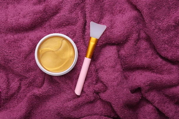 Jar of collagen golden patches on pink towel. Anti-aging care - Photo, Image