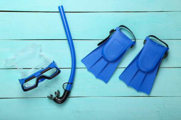 Dětské ploutve, šnorchl a potápěčská maska na modrém dřevěném pozadí. Horní pohled - Fotografie, Obrázek