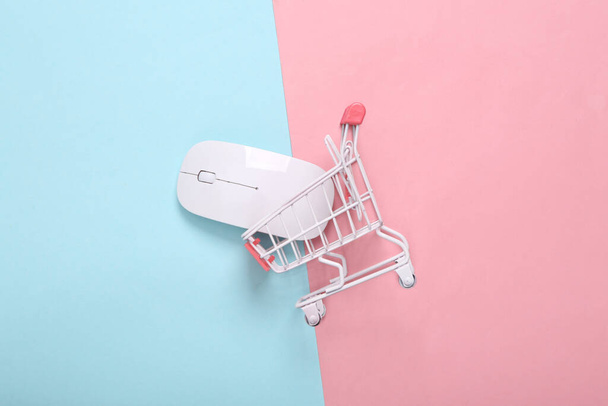 Carrello con mouse per pc su sfondo blu rosa. Shopping online - Foto, immagini