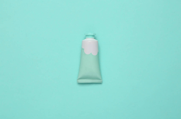 Tube of cream on a turquoise background. Top view. Minimalism - Photo, Image