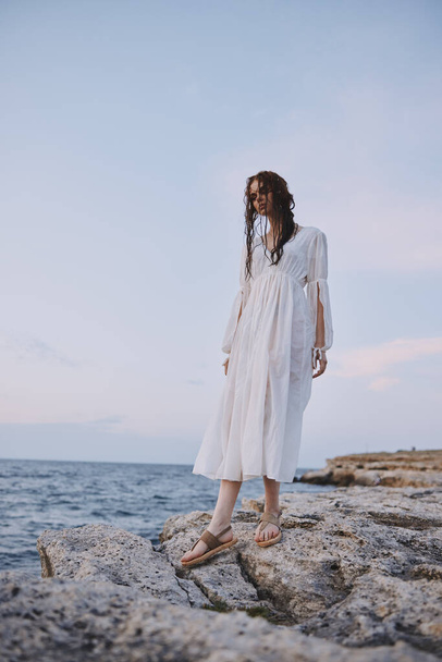 pretty woman in white robe landscape ocean rocks nature unaltered - Foto, Imagem