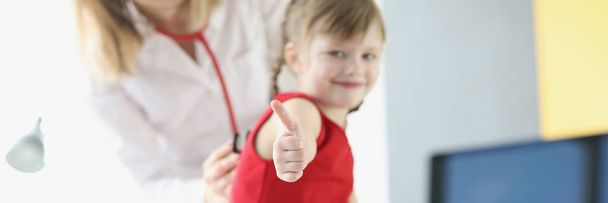 Kleines Mädchen beim Kinderarzttermin hält Daumen hoch - Foto, Bild