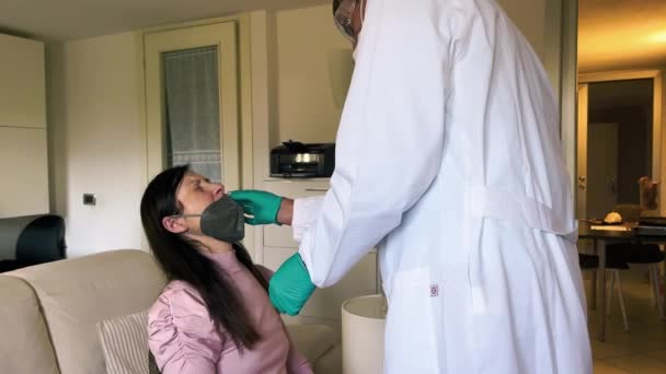 Covid preventie thuis. Arts testen vrouwelijke patiënt met een nasale uitstrijkje test . - Video