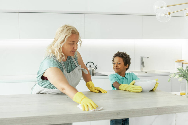 Mutter und Sohn putzen gemeinsam Küche - Foto, Bild