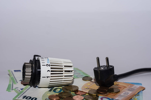 Energieprijzen stijgen en energieverbruik thermostatische regelaar verwarming en stekker onderaanzicht - Foto, afbeelding